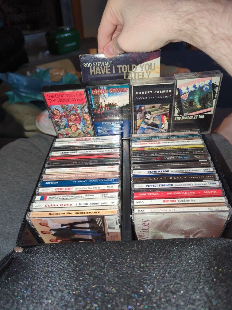 27 CDs And Four Cassette Tapes Of Varying Genre, From Country To Blues To Rock