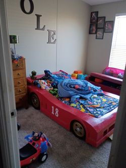 Kids race cars bed . This thing is made out of real wood so it does have a little bit of damage but it's got a custom canvas mattress pretty firm but 