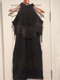 The Forever Unique Black Lace Fringe Halter Sleeveless Knee Length Shift Dress is a stylish and elegant option for parties or cocktail events. Made fr
