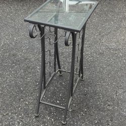 Wine holding metal table with a glass surface