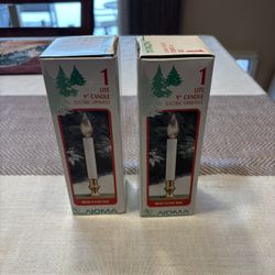 Two boxes of NOMA brand 9-inch electric window candles with brass-plated bases. 