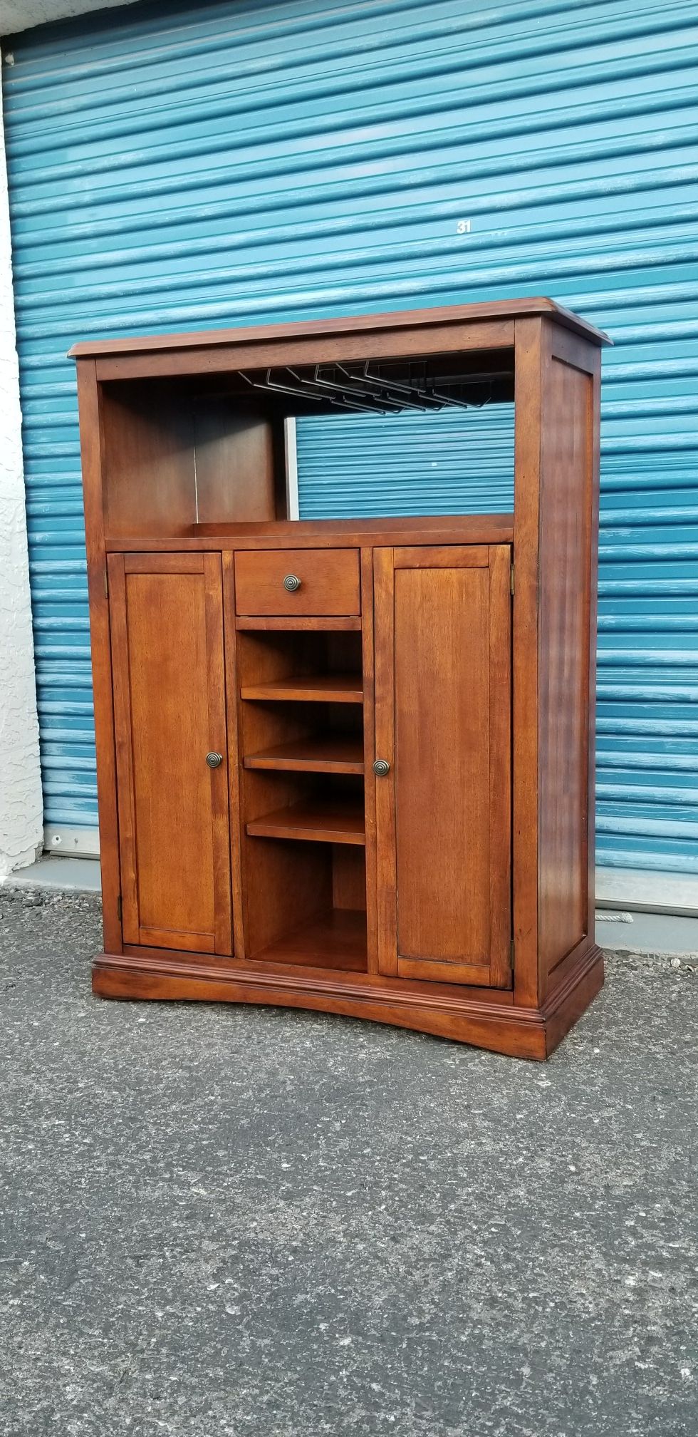 Bar cabinet with tile inserts. Has a small stemware rack and a mirrored back.