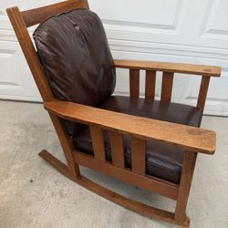 Nice solid wood rocking chair. Could be Stickley, but it unmarked.   Height with back: 34" Height of the seat: 16" Depth: 28.5" Width with handles: 29