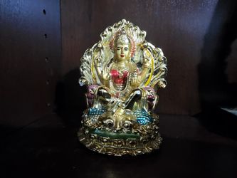 Intricately designed gold-colored Hindu Goddess Lakshmi figurine with vibrant details.