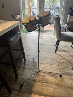 wooden bongo drums mounted on an adjustable double-braced chrome tripod stand.