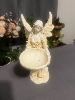 Elegant resin angel statue is cream-colored with a textured finish. It has a standing angel figure holding a shallow bowl. The material is durable res