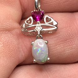 This Lightning Ridge opal pendant is set in 925 silver with a  925 chain plated. Opal is an 8x6x3mm 0.82ct with white Topaz and Garnet