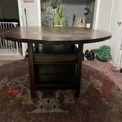 Heavy pub style table with lazy susan and 4 chairs  Very heavy has wine rack underneath has a Lazy Susan on top chairs are in good condition. There ar