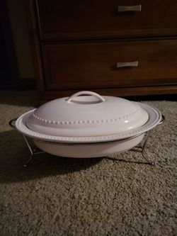 Stoneware covered casserole with stainless steel warming stand.