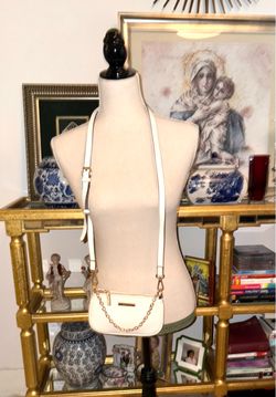 Anne Klein's elegant white crossbody bag stands out for its refined gold chain detail.