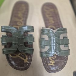 pair of Sam Edelman Women's Bay Slide Sandals in an olive green crocodile-embossed leather. 