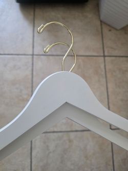 Off white matte wooden hangers with gold hook.  Brand new