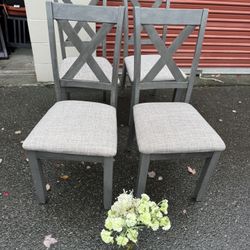 Grey wooden table and four chairs and a bench