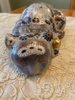 Vintage chinoiserie porcelain Asian sleeping cat statue with gold accents & floral design.