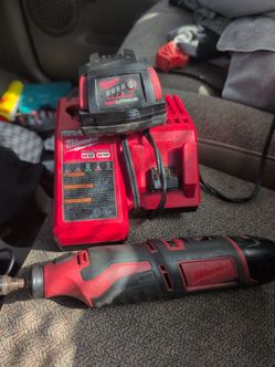 Milwaukee rotary tool along with 12-volt battery and also a M12 M18 charger and a M18 battery red lithium