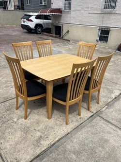 Large wood dining table set with 6 padded chairs Includes expansion leaf Table