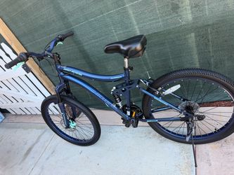 Genesis Bella Vista 24-inch full-suspension mountain bike in blue with contrasting teal accents.