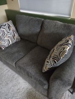 Dark gray love seat with pillows