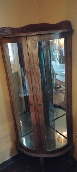 Curved glass oak corner curio cabinet.