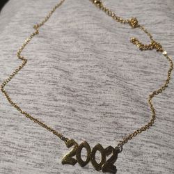 Gold Colored Chain With '2002' Pendant