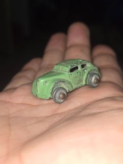 small vintage green metal or lead-alloy toy car, commonly known as a slush cast or diecast model from manufacturers like Barclay or similar 1930s–1950