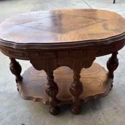 antique wooden parlor or center table, likely featuring carved walnut and ornate legs similar to Victorian or Spanish Revival styles.