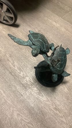 sculpture of sea turtles on a marble base.