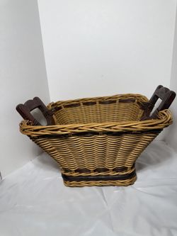 This is a vintage 1970 two-tone handcrafted wicker basket with bentwood handles and a wooden slat bottom.