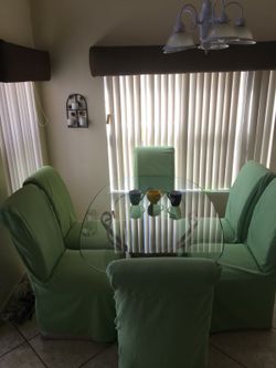 Glass dinning room table with six seat covered chairs
