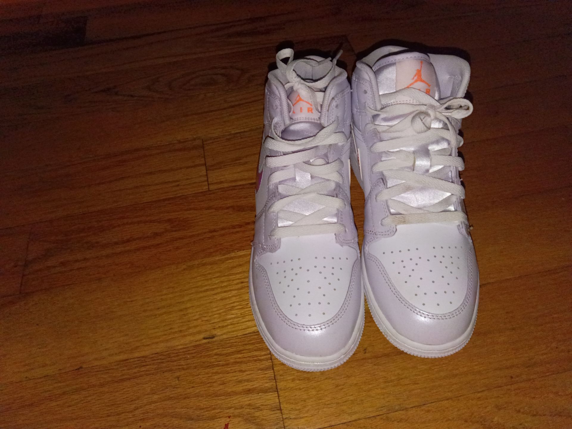 Nike Air Jordan 1 Mid SE kids' shoes in the "Barely Grape" colorway, featuring a white leather upper with iridescent swooshes.