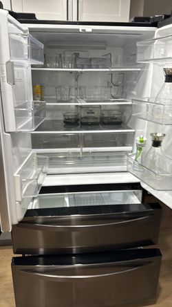 Black stainless steel Kenmore refrigerator with icemaker and French doors