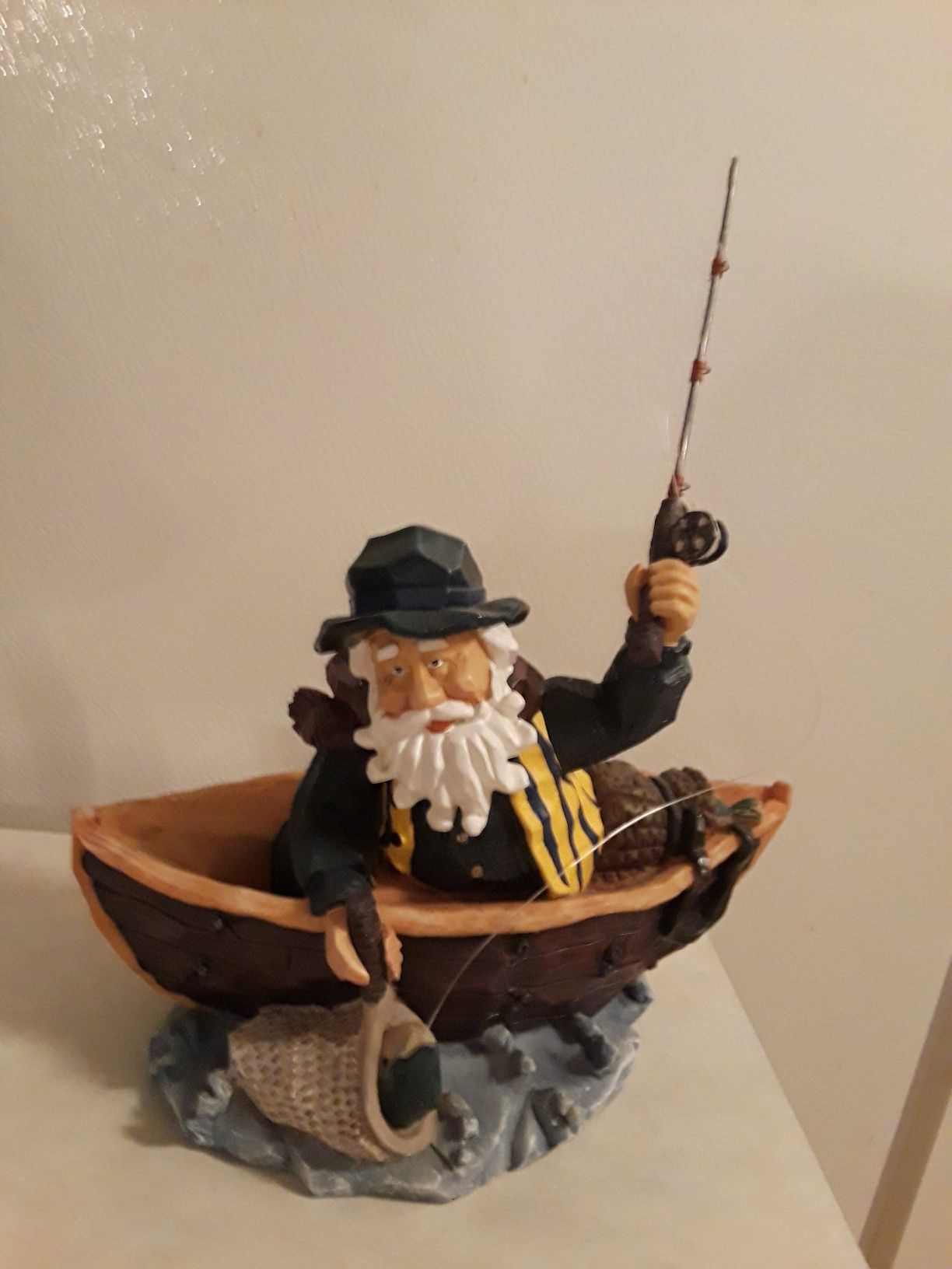 Old bearded fisherman Figurine with Pole and net fishing in boat on water