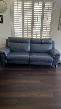 Two reclining leather couches, teal color