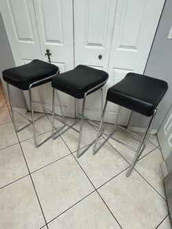 contemporary black faux leather backless bar stool featuring a sleek chrome steel tube frame.
