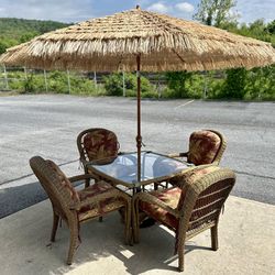 Wicker dining table with four chairs plus Tiki umbrella, and cast-iron stand 