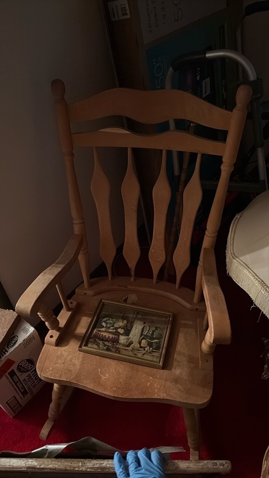 A rocking chair and two walkers one sit on walker and one normal walker