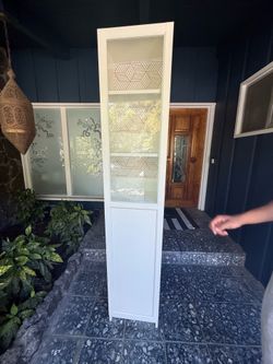 Tall white glass bookcase