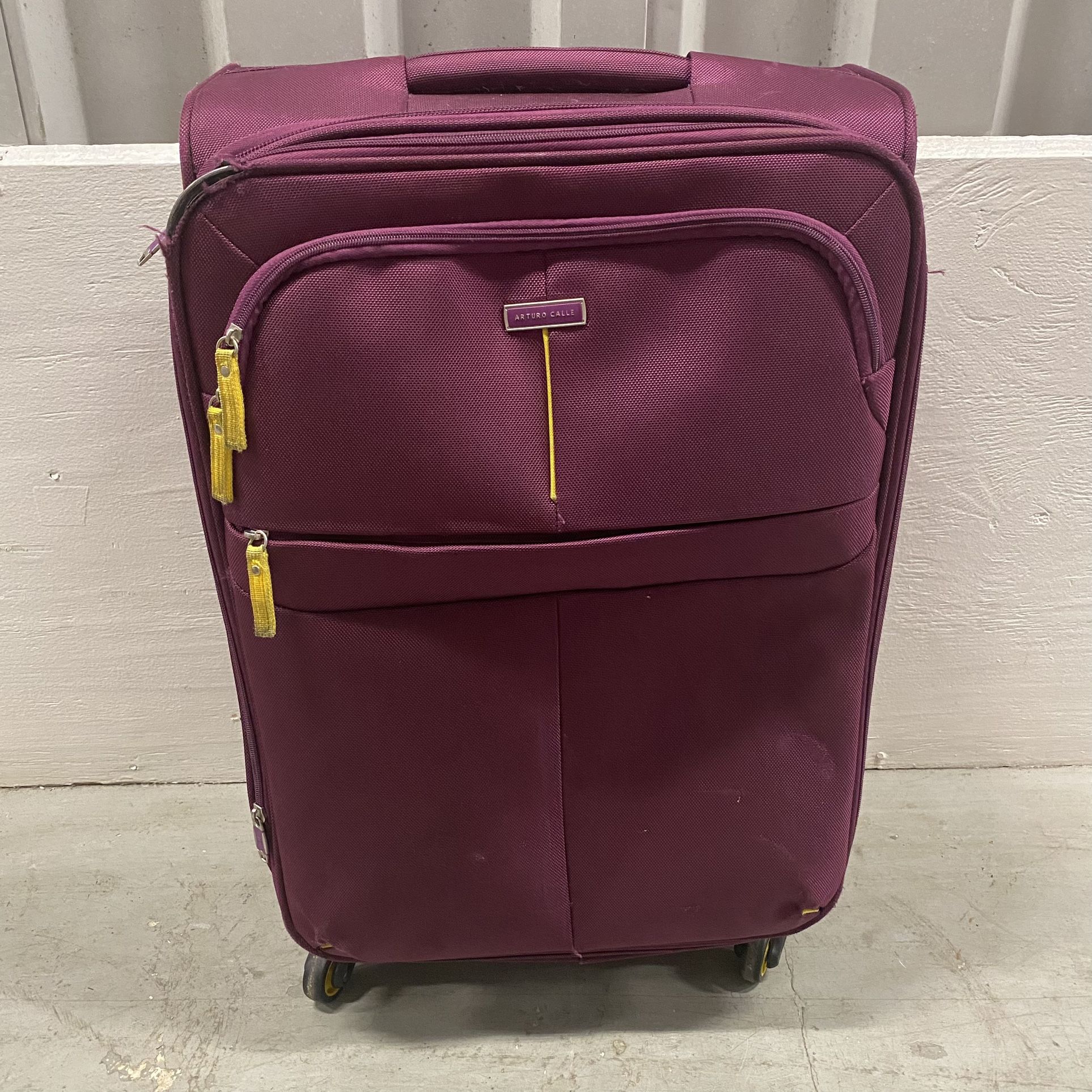 ARTURO CALLE Maroon Luggage Suitcase Travel Checked Bag 24” 4-Wheel Spinner with Yellow Accent Trim Good pre-owned condition. There is one corner of