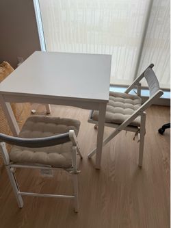 IKEA hauga table and two IKEA tonstad chair with cushion