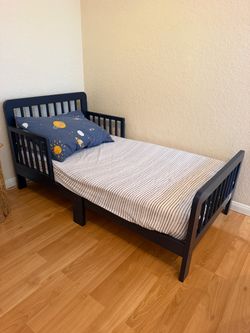 Navy blue toddler bed includes a newton mattress