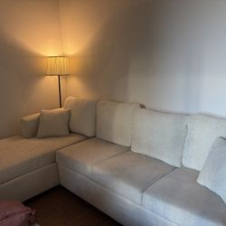Cream sectional Sofa With Chaise, Ottoman, And Cream Pillows 