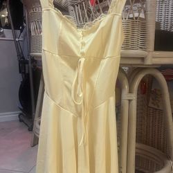 Yellow mini dress with lace trim and a tie front.