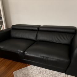 Adjustable Headrest Metal Trim Leather Sofa, a modern piece featuring black genuine leather, built-in adjustable headrests, and distinct metal accent