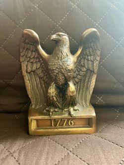 vintage cast metal American eagle with a brass finish and "1776" engraved