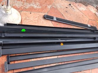 The items laid out on the ground are structural industrial pallet rack beams and upright frames or bulk heavy-duty storage shelving components, consis