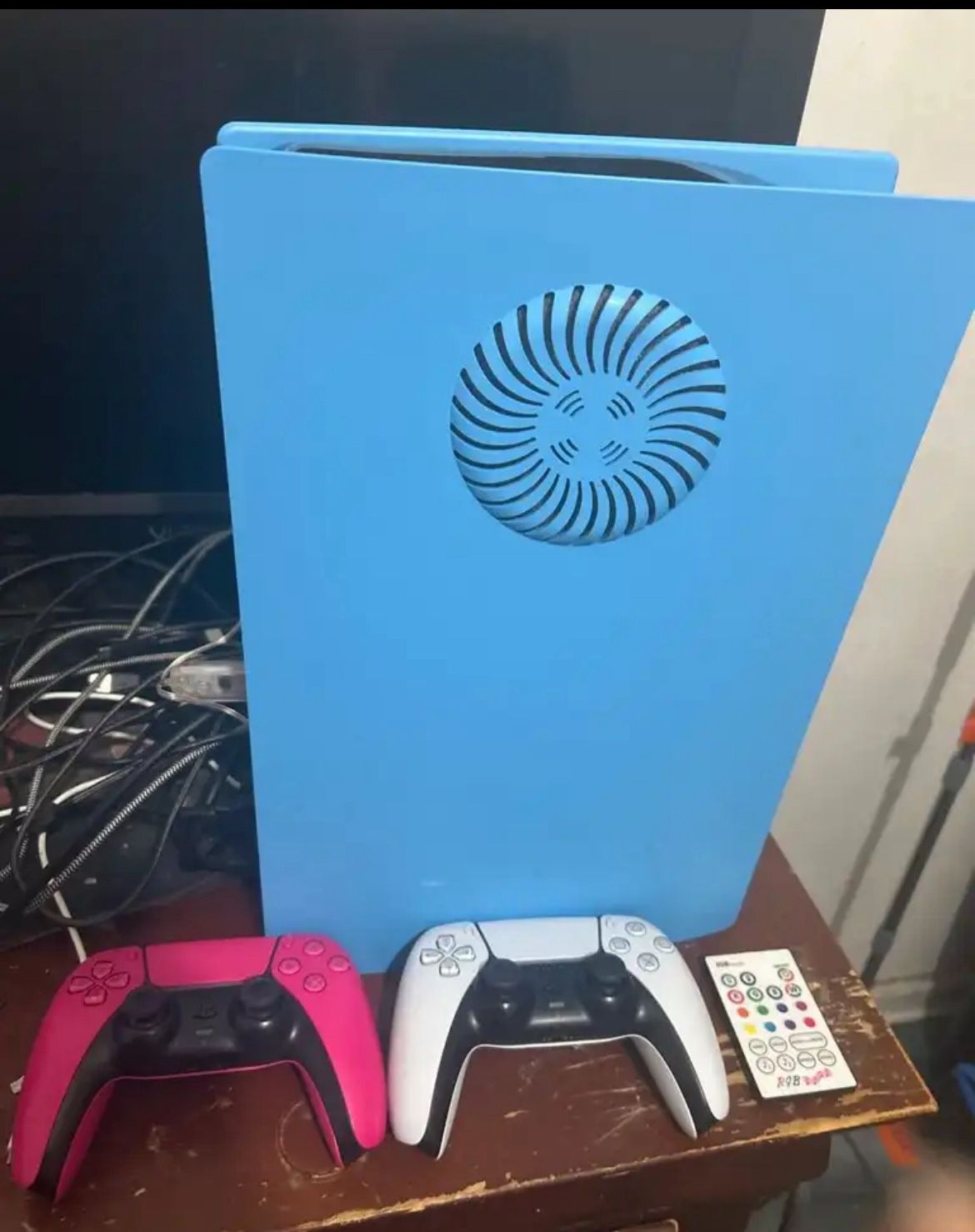 PS5 With Controllers, Cords, And Blue Faceplate That Lights Up