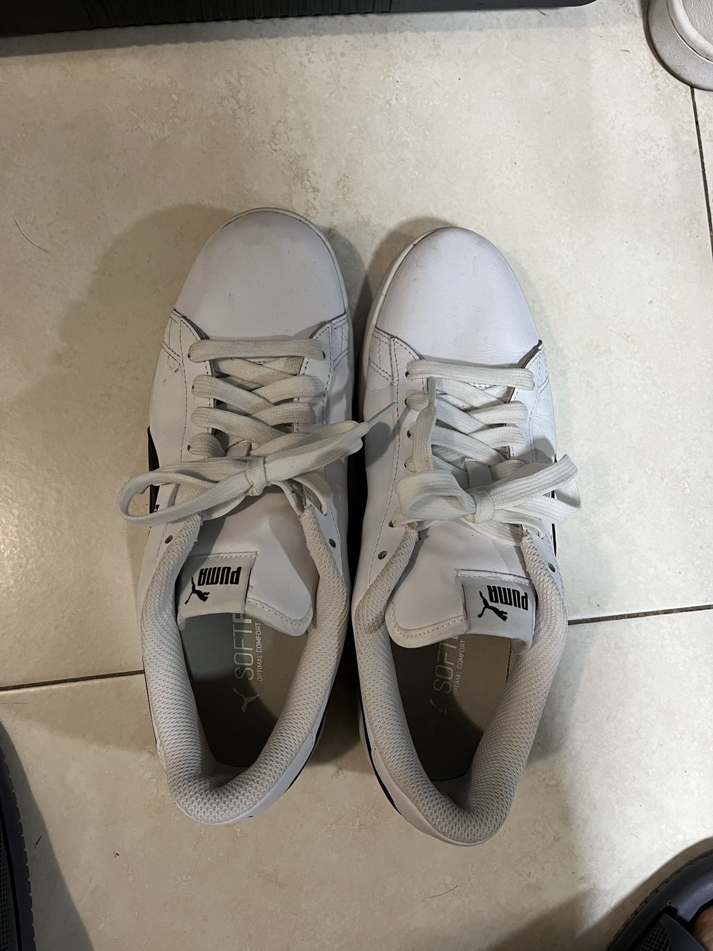 White Puma tennis shoes with black accents