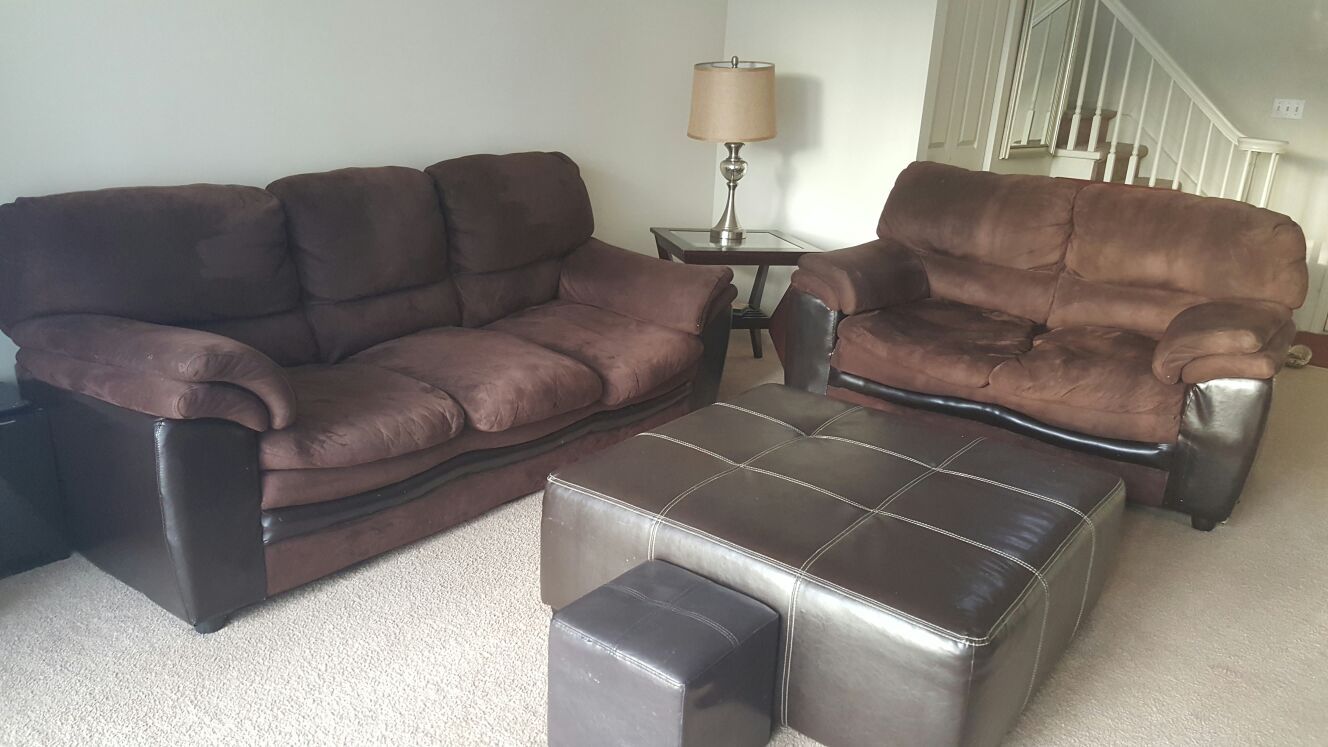 A very luxurious Chocolate micro fiber cloth sofa and love seat with black leather on the sides.