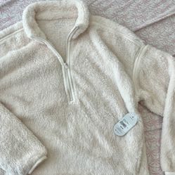 Ultra-soft cream sherpa pullover with a half-zip neckline. Lightweight yet warm fleece for everyday layering. Relaxed fit with trimmed seams for a cle