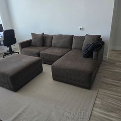 Brown fabric L shaped sectional with ottoman.